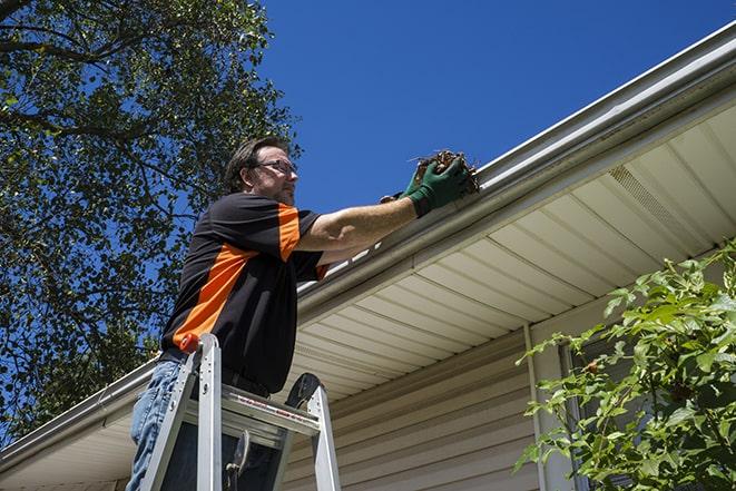 a team working together to repair a damaged gutter system in Laton CA